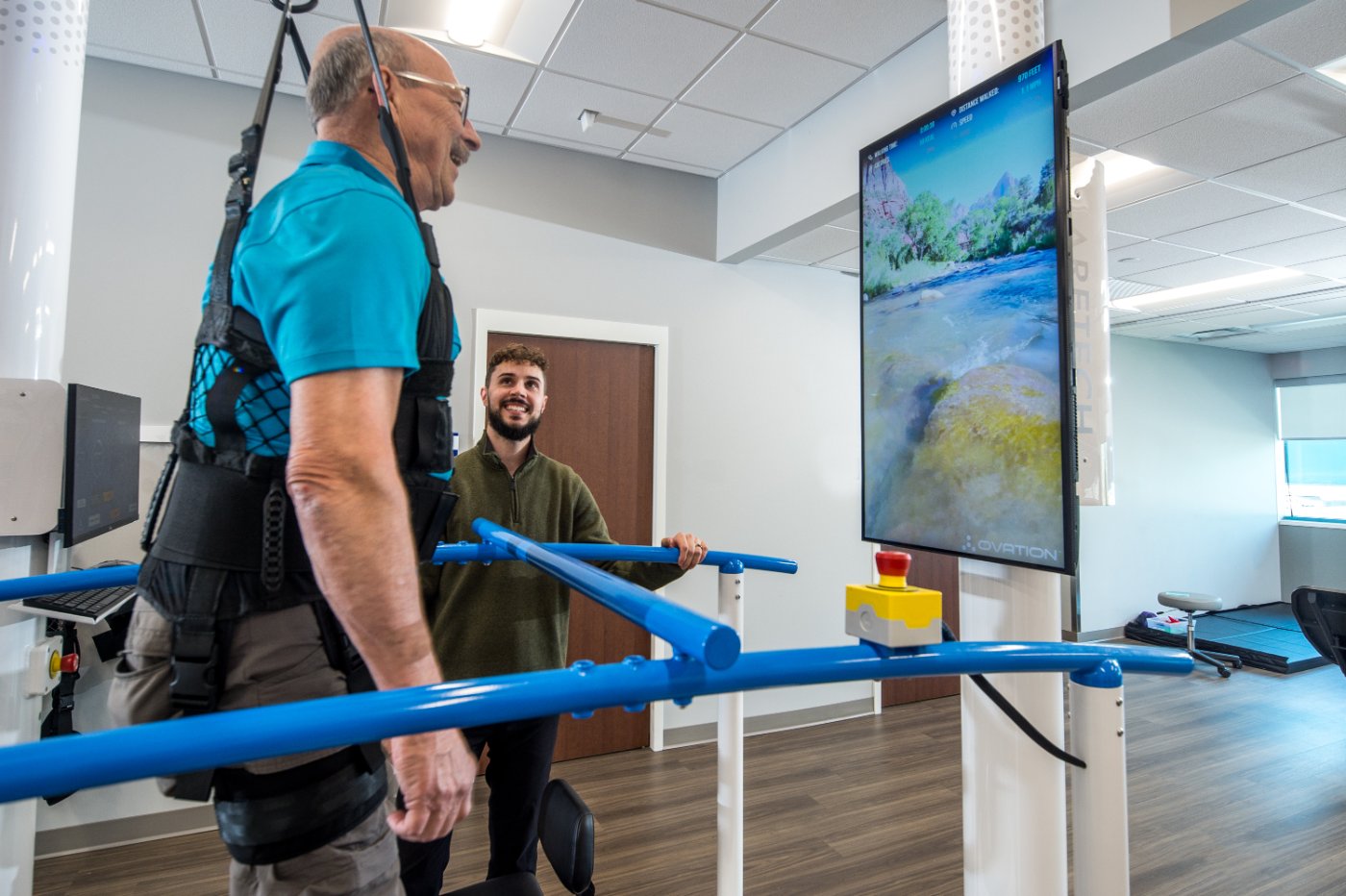 Patient walking on Ovation toward the Infotainment Display while a therapist looks on