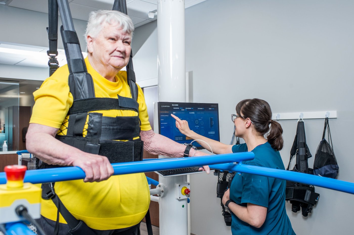 Patient in a wheelchair rolling up the Ovation Launchpad ramp with a therapist guiding