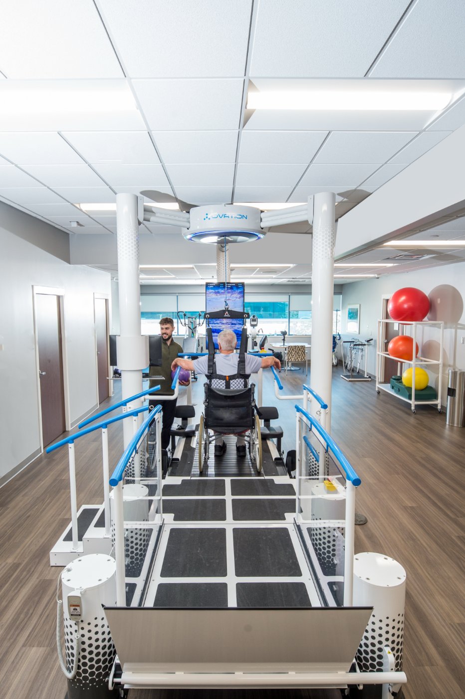 Patient in a wheelchair on the Ovation Launchpad with a therapist assisting during a transition