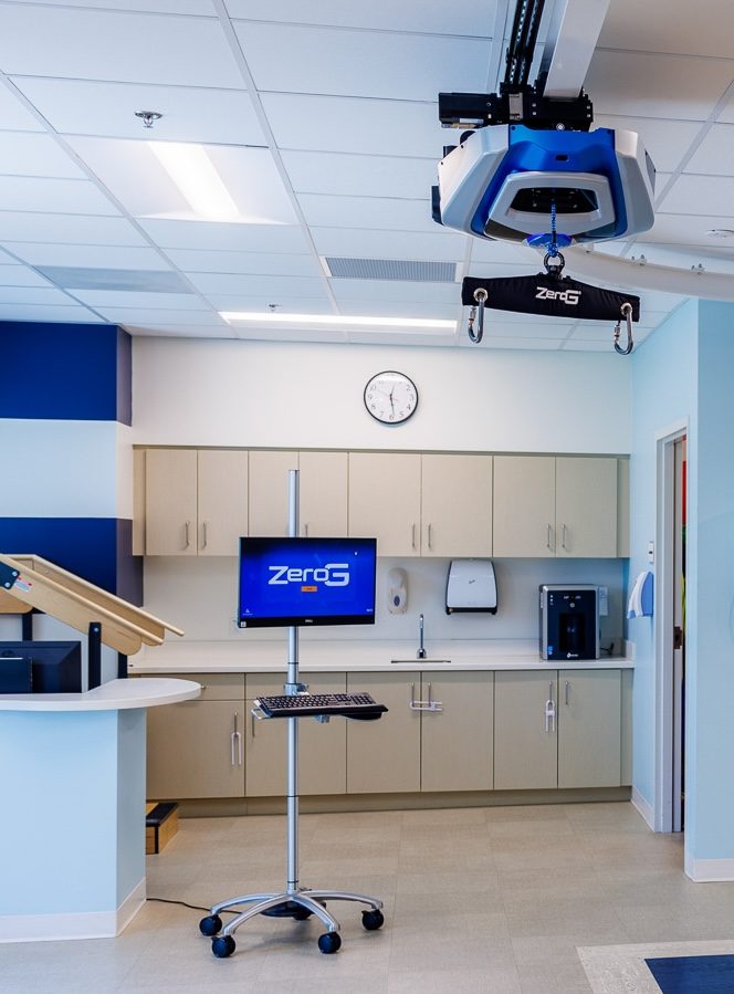ZeroG touchscreen interface on a mobile stand in a therapy room